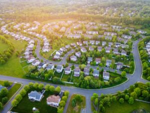 a mountain neighborhood pictured from above, it is a beautiful summer day