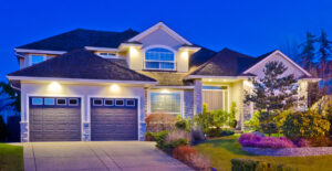 a home in Banner Elk NC lit up at night. flowers are in the front yard